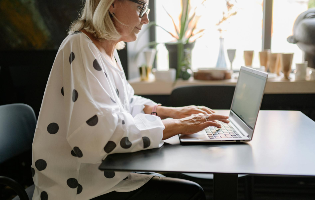 Woman sitting at her laptop and filling out an online form.